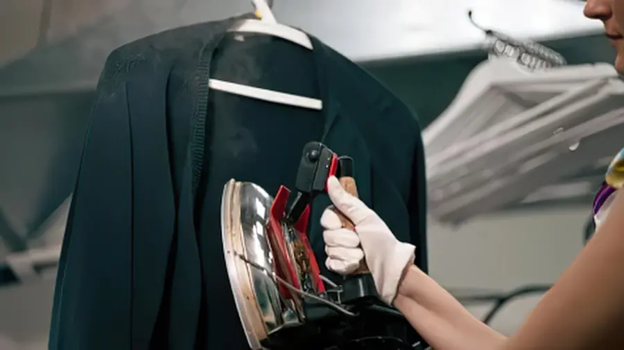 A jacket being steam pressed by hand