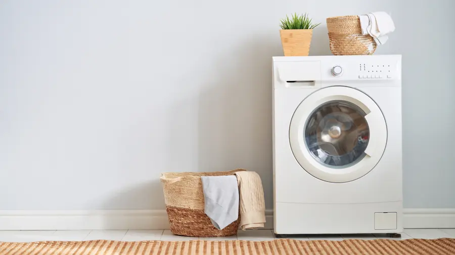 Folded laundry beside a washing machine